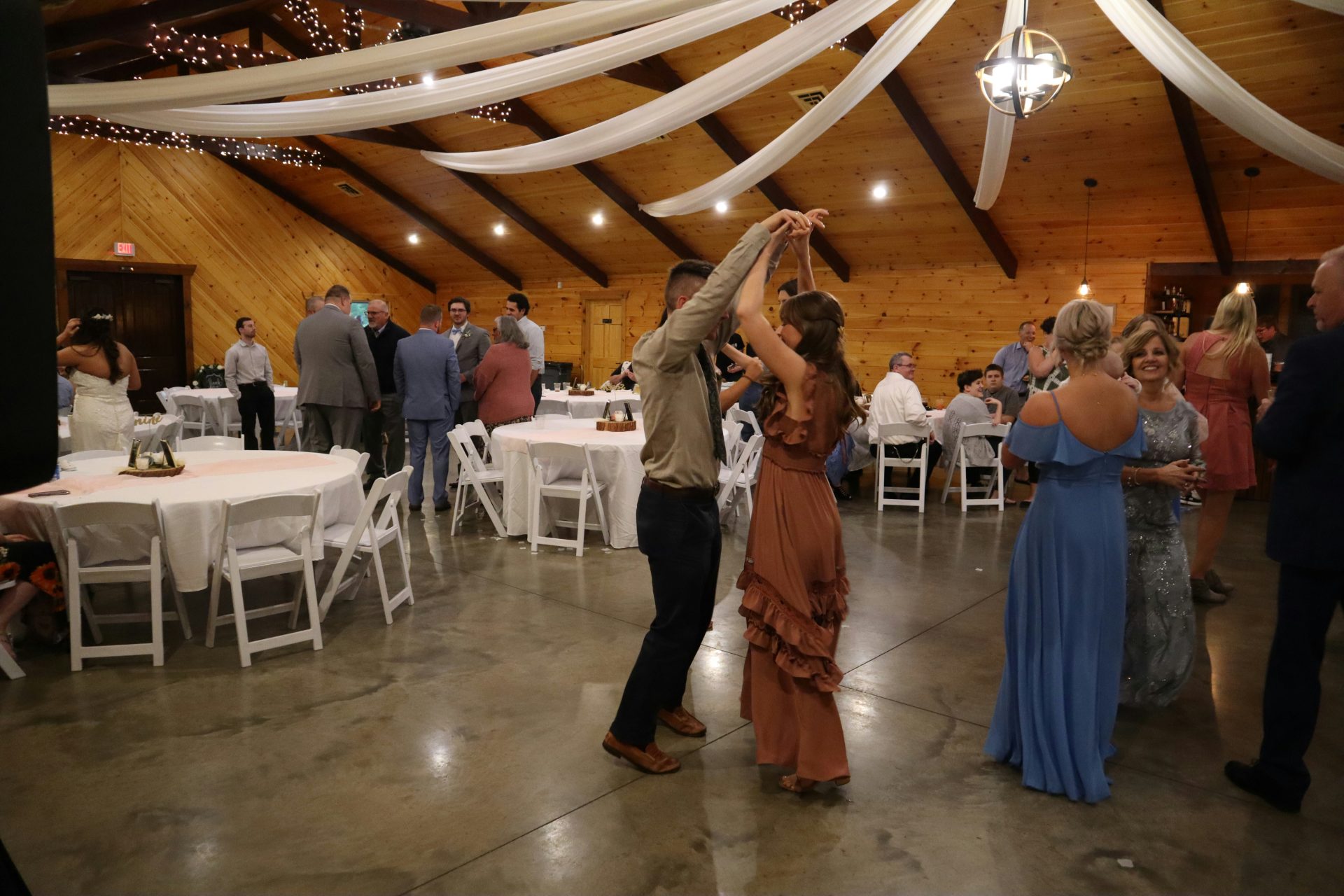 a man and woman dancing in a room with tables and chairs