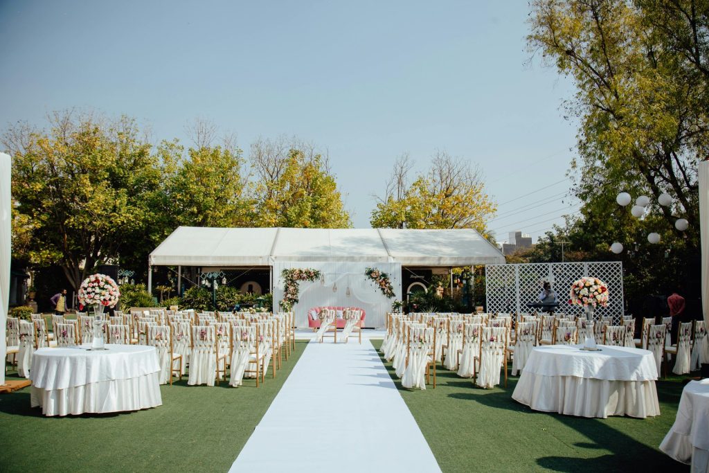 Un magnifique décor de mariage en plein air, avec d'élégantes compositions florales sous un ciel dégagé.