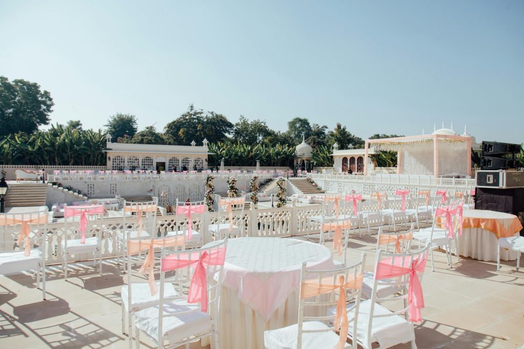 Décoration élégante en plein air pour un mariage, avec des éléments et des sièges aux tons pastel, idéale pour un événement dans un jardin.