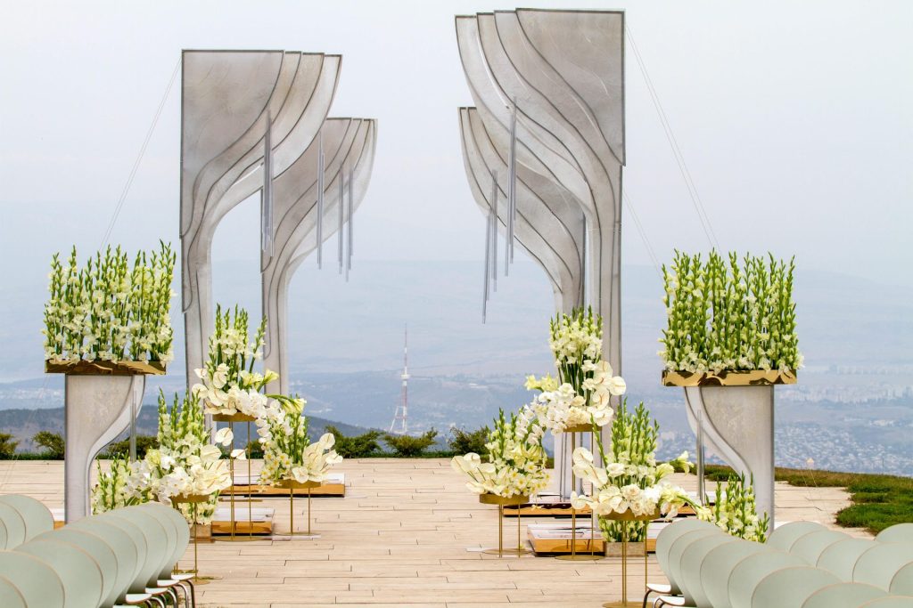 Un lieu de mariage en plein air exceptionnel, orné de compositions florales blanches et de structures architecturales.