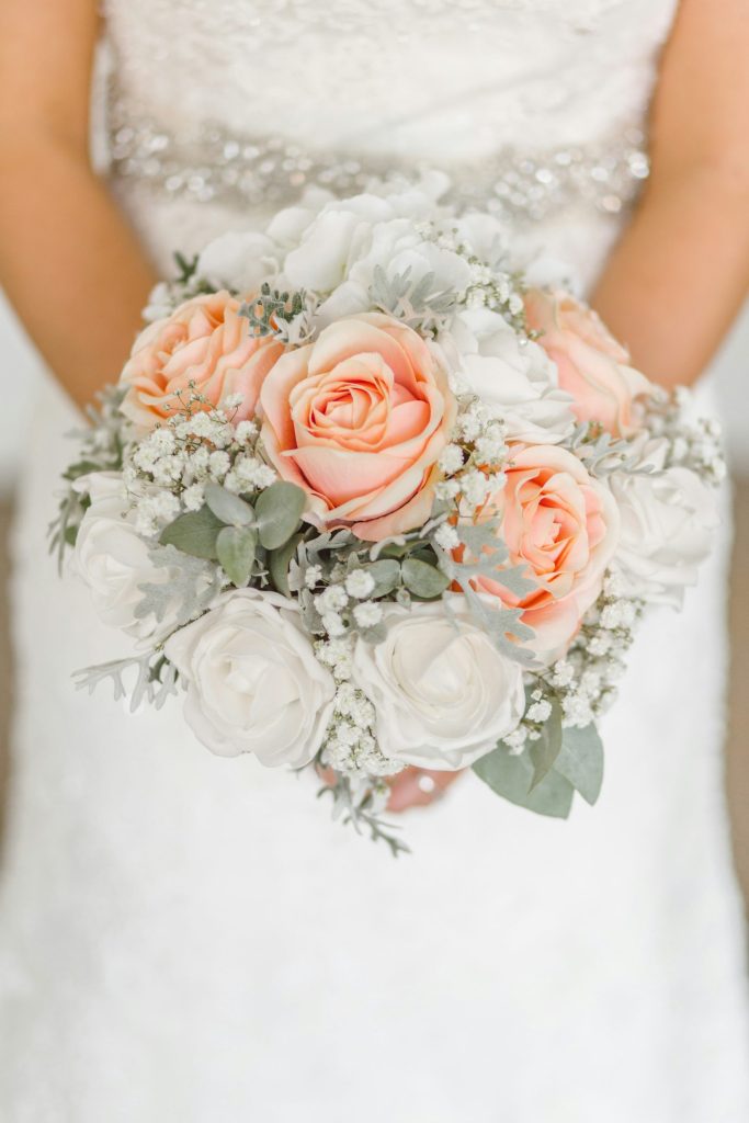 femme tenant un bouquet de roses blanches et roses