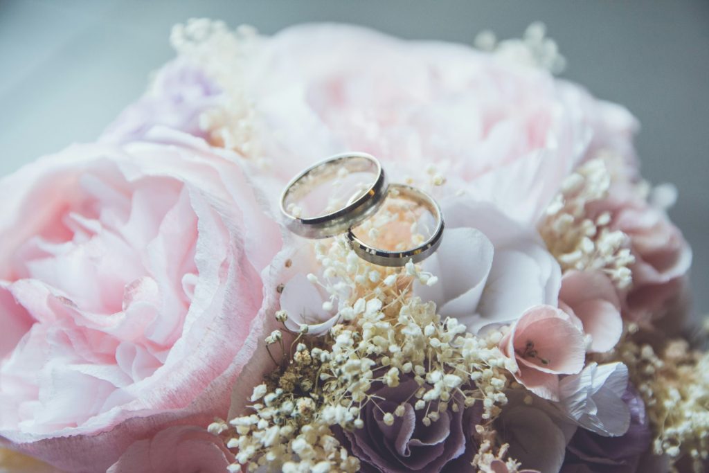 Bague de fiançailles dorée sertie sur un bouquet de roses roses